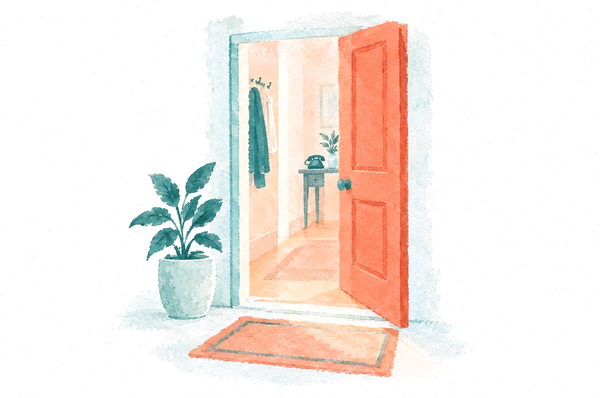 An open coral front door with warm light spilling onto the doormat